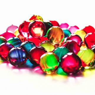 A selection of bright, colourful path pearls on a white background.