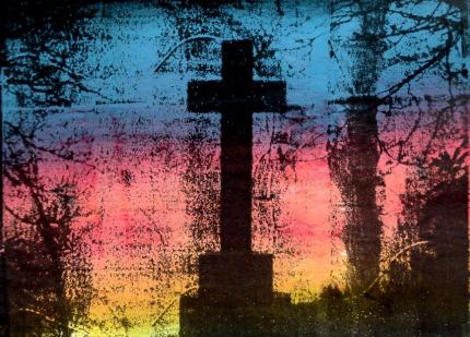 A mixed media print showing a silhouette of a large cross in graveyard with a colourful sunset behind it.